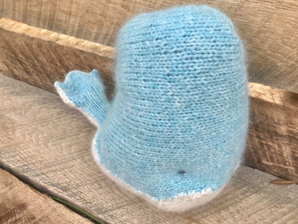 blue and white knit whale on wooden background