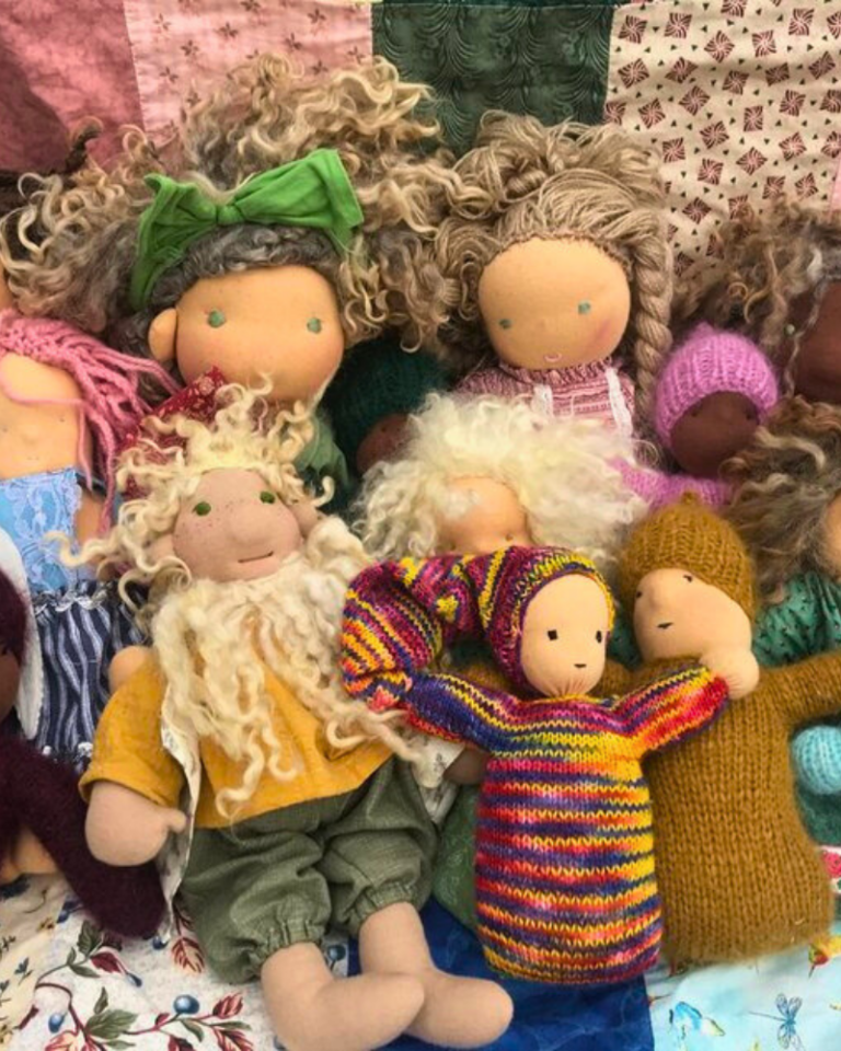 featured image of collection of handmade waldorf dolls sitting on a colorful quilt