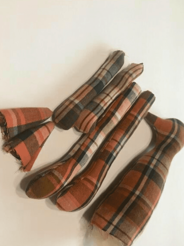 pieces of an orange flannel fox stuffed and on a white background