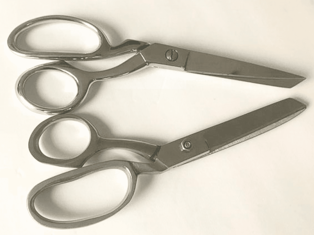 two pairs of stainless steel sewing shears on white background